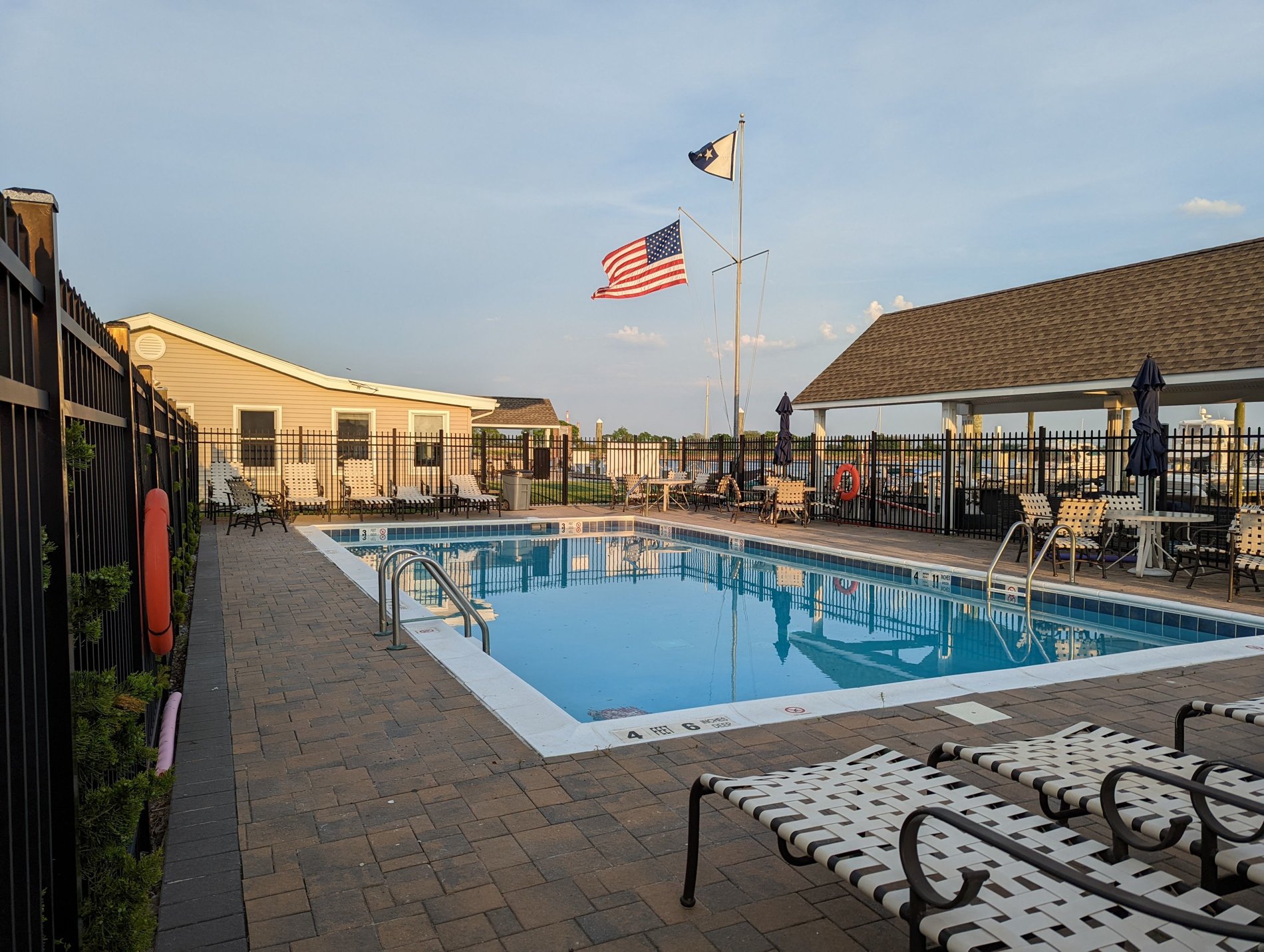 The outdoor swimming pool and seating area at Woodmere Bay Yacht Club